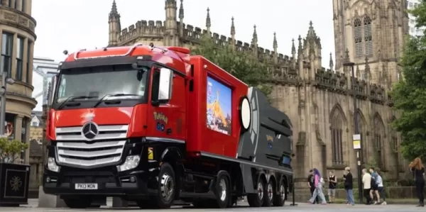 Um caminhão vermelho com adesivos do Pokémon Go dirige pelas ruas de Londres